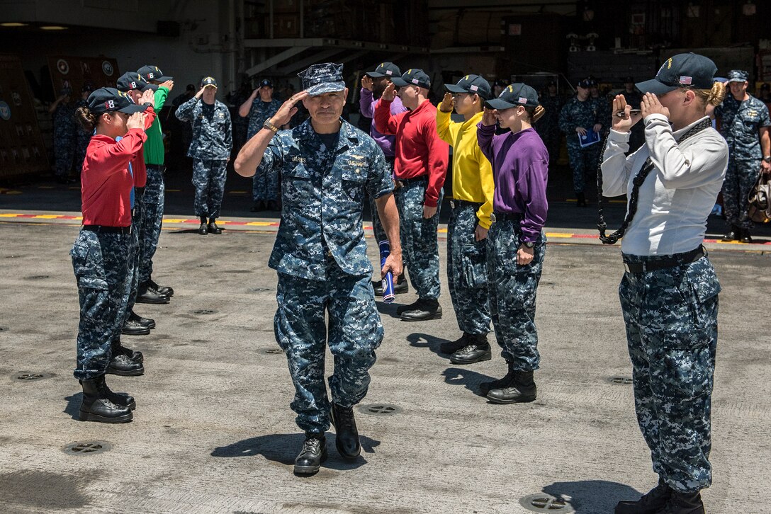 The commander of U.S. Pacific Command renders a hand salute as he walks through side boys.