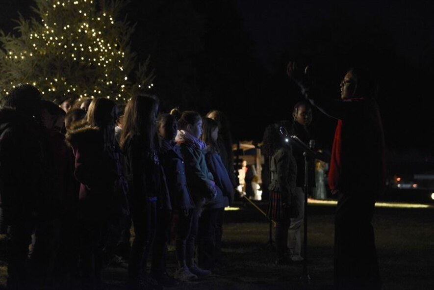 Shaw Heights Elementary School choir sings holiday songs during a Christmas Tree Lighting/Religious Display Interfaith Ceremony at the Friendship Chapel, Dec. 3, 2015, at Shaw Air Force Base, S.C., Dec. 3, 2015. The evening began with a performance from the Shaw Heights Elementary School choir followed by the religious display and tree lighting. (U.S. Air Force photo by Airman 1st Class Christopher Maldonado)