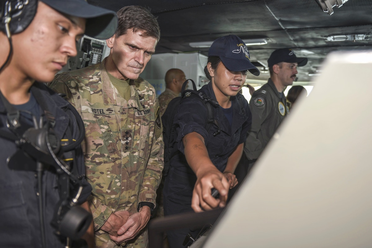 The commander of U.S. Central Command visits with sailors on a ship.