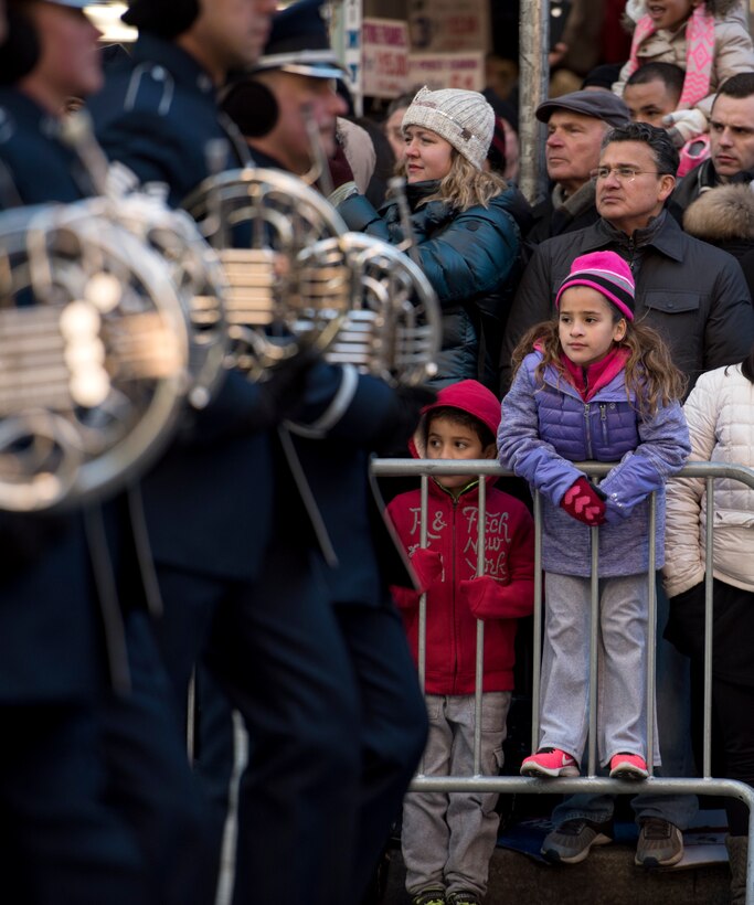 Crowd members watch band march