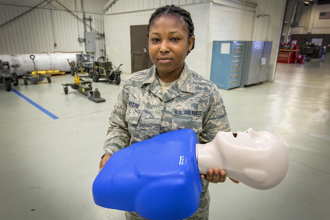 Air Force Senior Airman Selina N. Okyere, a crew chief with the 514th Maintenance Squadron, 514th Air Mobility Wing, Air Force Reserve Command, poses with a CPR mannequin at Joint Base McGuire-Dix-Lakehurst, N.J., July 16, 2017. Okyere created a nonprofit organization to teach basic first aid skills to the citizens of Ghana. Air Force photo by Master Sgt. Mark C. Olsen
