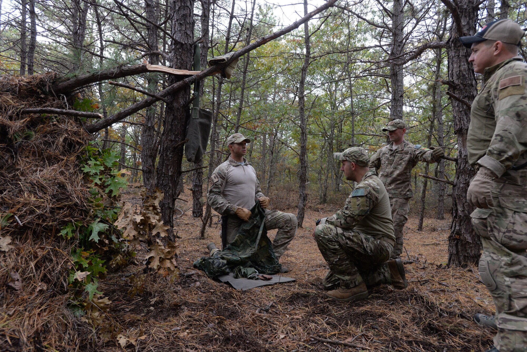 Senior Airman Alexander Triani, a pararescueman with the 103rd Rescue Squadron of the 106th Rescue Wing assigned to the New York Air National Guard, demonstrates how to make a mattress from a used parachute in the woods of Westhampton Beach, New York November 1, 2017.