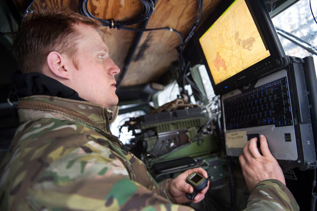 An airman enters grid coordinates into a computer