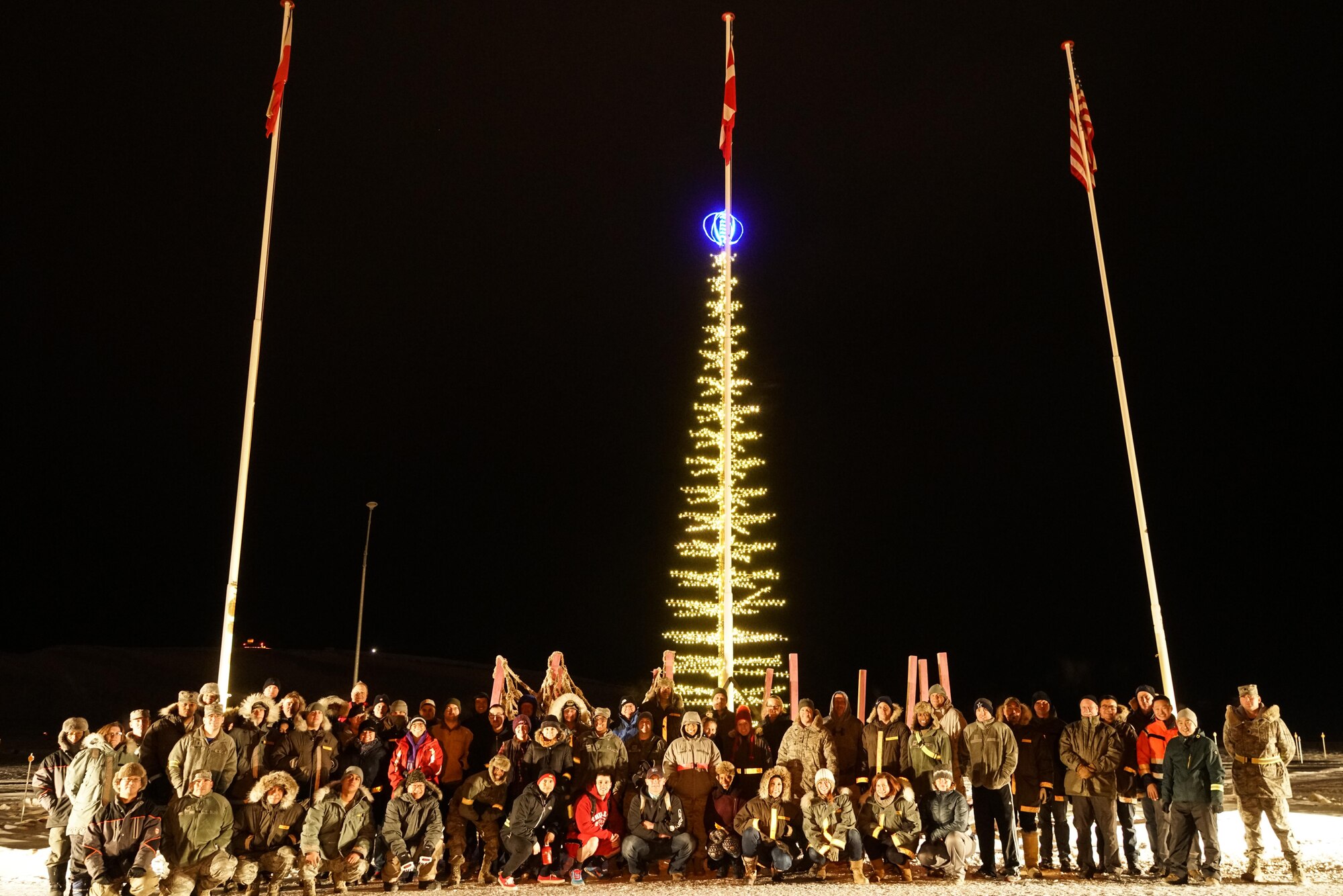 Thule Air Force Base, Greenland -- Col. Thomas Colvin 821st Airbase Group commander and the Capt. Richard Casey 821st ABG chaplain kicked off the holiday season during the annual Tree Lighting Ceremony at Thule Airforce Base, Greenland, on Nov. 17, 2017.  Afterwards, Airmen spent time wrapping gifts for over 200 local children from nearby villages as part of Operation Julemand.  Operation Julemand was first started in 1959 by base service officer Capt. John McTamney, and Airman 1st Class Delbert Cox, a clerk, when they decided that since they couldn’t be at home with their own children, they would bring a little happiness to the children in the local area. (Courtesy photo)