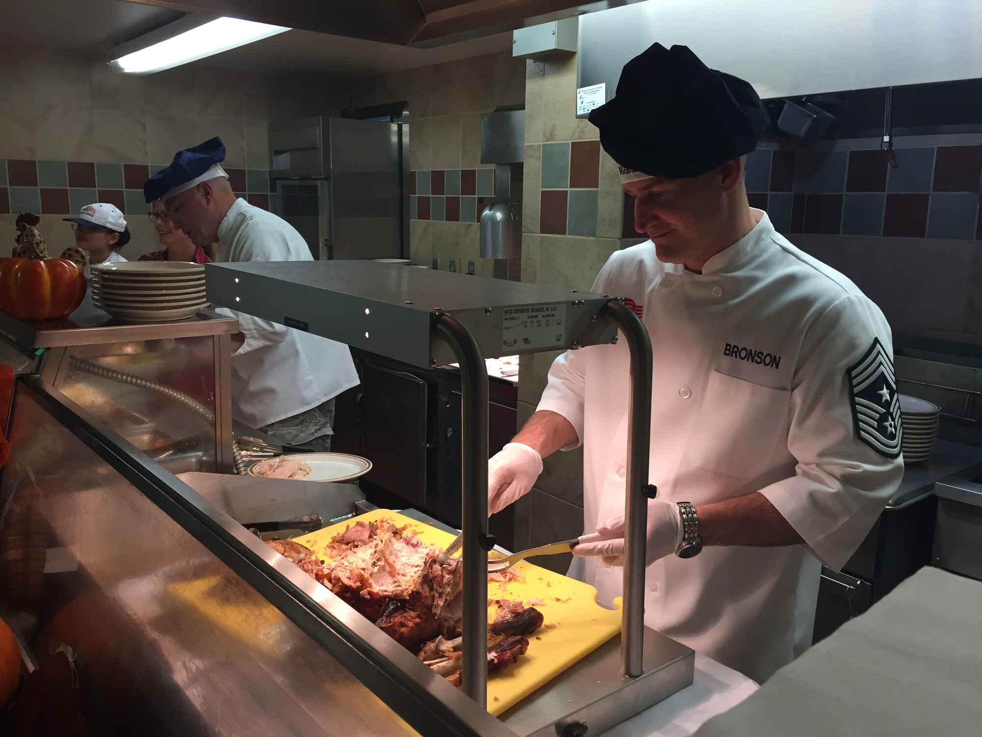 Chief Master Sgt. Mark Bronson , 21st Space Wing command chief, serves Thanksgiving dinner at the Aragon Dining Facility on Peterson Air Force Base, Nov. 23, 2017. The dining facility stays open during holidays so that Airmen with mission critical jobs have the opportunity to get a little taste of home. (U.S. Air Force photo by Capt. Melanie Reeves)