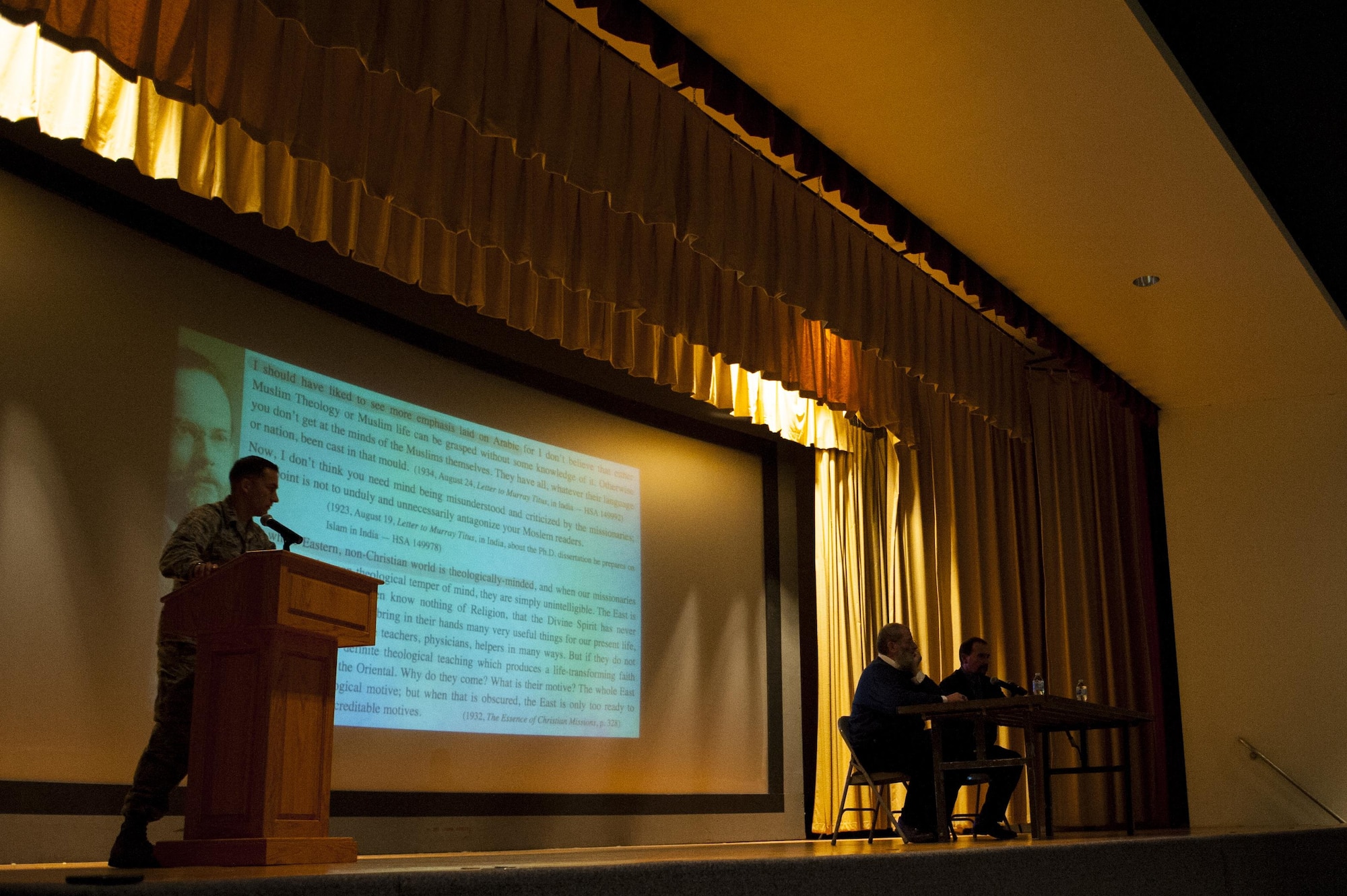 U.S. Air Force Capt. Iskandar Atajanow, 17th Training Wing chaplain, hosts the panel discussion for Dr. Yahya Michot, Hartford Seminary professor, and Anthony Celso, Angelo State University professor of security studies, answering questions from the crowd about Islamic extremism at the Base Theater on Goodfellow Air Force Base, Texas, Nov. 20, 2017. Michot and Celso gave separate lectures on Islamic extremism, specifically the Islamic State of Iraq and the Levant, and then sat together and answered questions from the audience. (U.S. Air Force photo by Senior Airman Scott Jackson/Released)