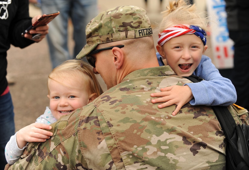 Army Staff Sgt. Keith Fitzgerald hugs his family in Huron, S.D., after returning from a 10-month deployment to the Middle East.