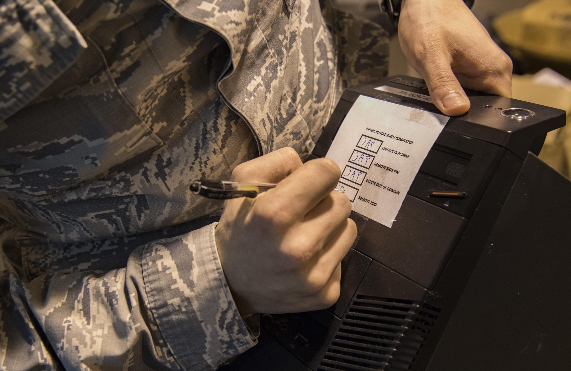 U.S. Air Force Tech. Sgt. James Providenti, 130th Communications Flight Supervisor, signatures a box showing hard drive removal on a computer Nov. 28, 2017 at McLaughlin Air National Guard Base, Charleston, W.Va.