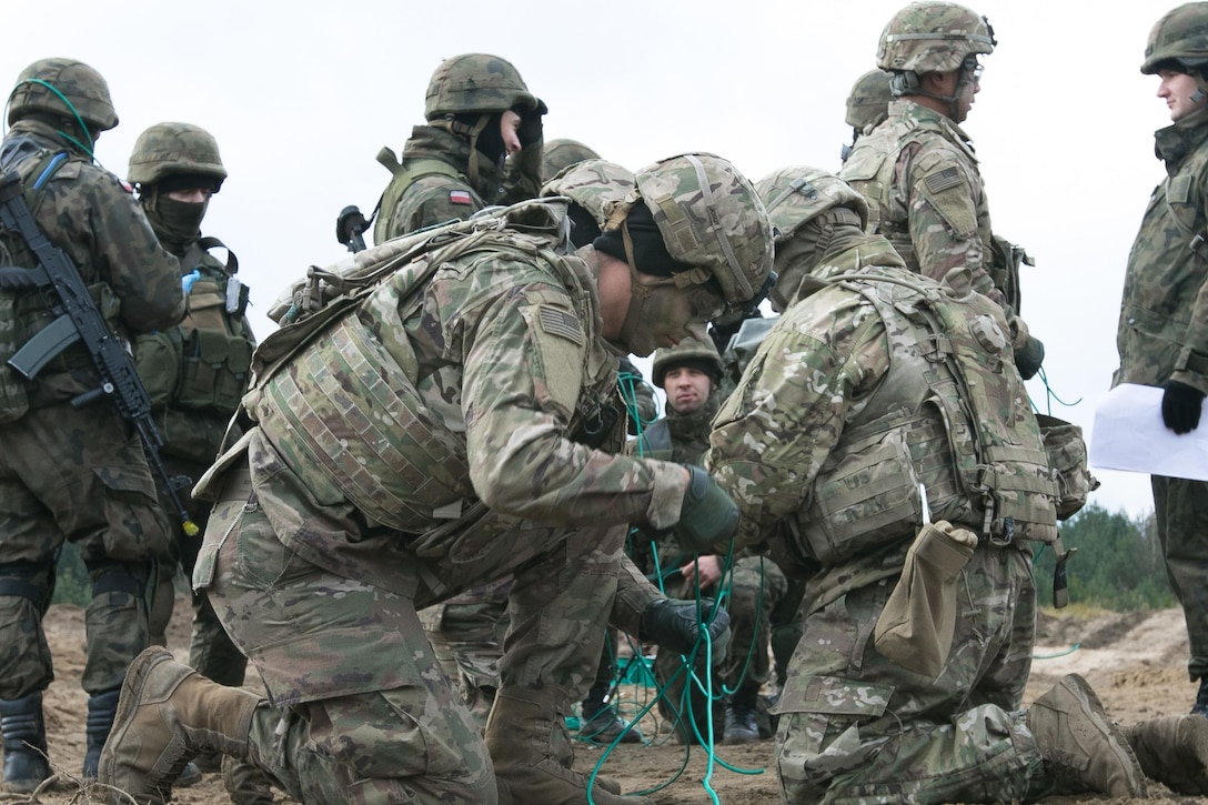 U.S., Polish soldiers train in laying out detonation cords.