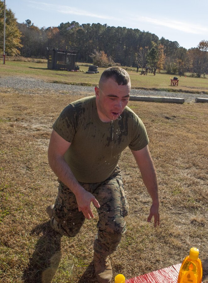 Pfc. Jake Starkey, student, Basic Security Guard Course 2-18, Training Co., U.S. Marine Corps Security Forces Regiment, kneels at the eye wash station to remove oleoresin capsicum spray from his eyes and face at Naval Support Activity Northwest Annex, Chesapeake, Va., Nov. 28. Marines had to wrestle another Marine who was also OC sprayed to demonstrate ground combat techniques for 60 seconds before they were certified. (Official U.S. Marine Corps photo by Chris Jones/Released)