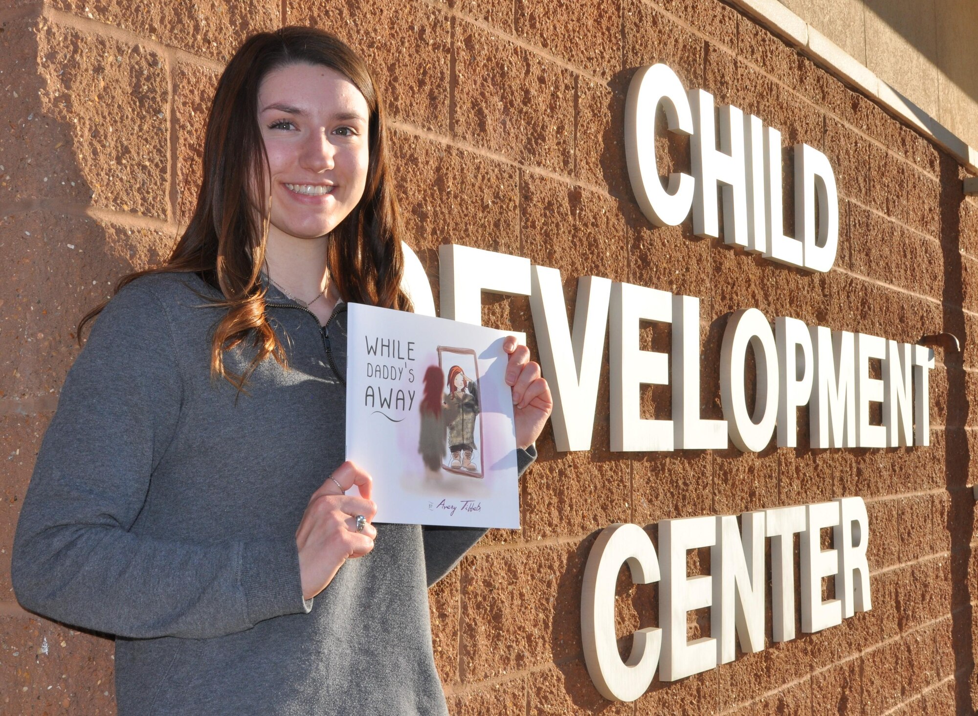 Avery Tibbets, daughter of Brig. Gen. Paul W. Tibbets IV, deputy commander, Air Force Global Strike Command, poses with a book she authored for military children.