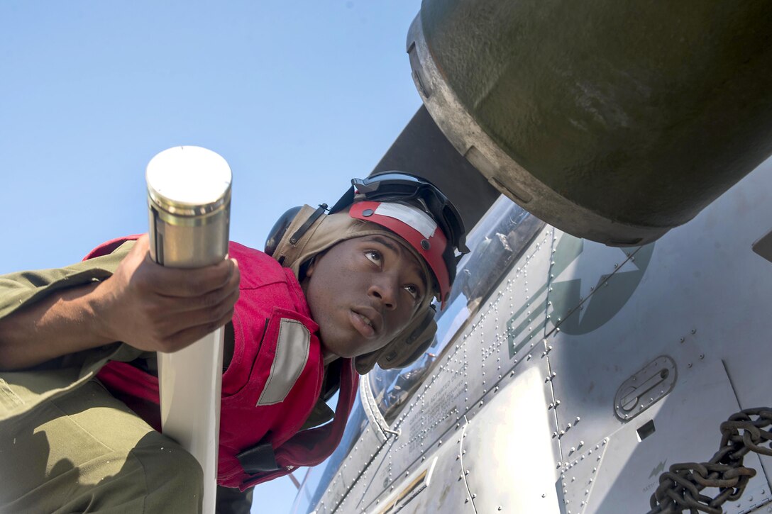 A Marine leans forward while holding a rocket.