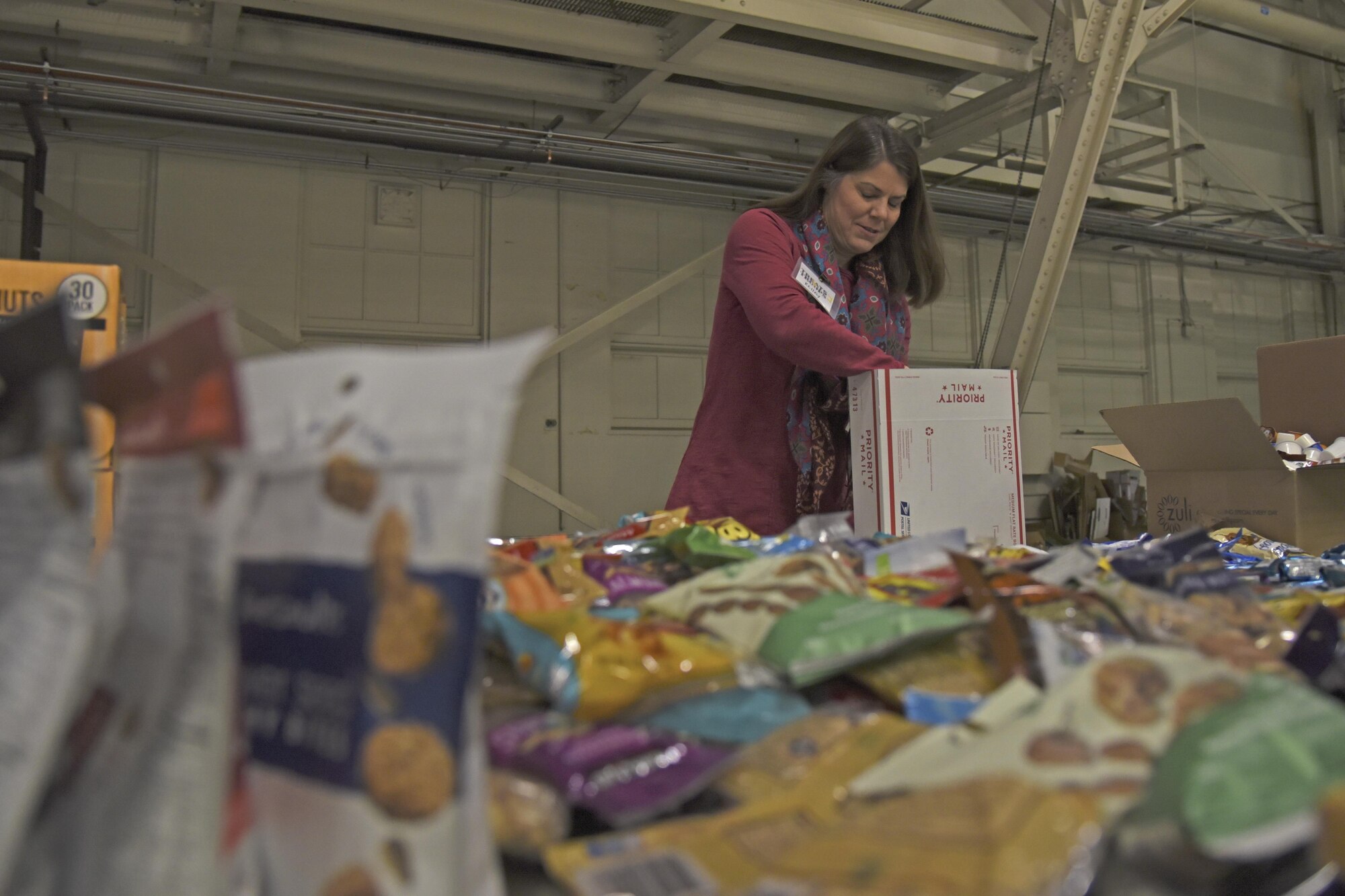 Kelley Cargle, Officer Spouses’ Club vice president of operations, packs a Treats 2 Troops care package with snacks Nov. 29, 2017, at Fairchild Air Force Base, Washington. KREM 2 News began collecting donations the beginning of November and collected thousands of items in less than a month to benefit military members serving overseas during the holiday season. (U.S. Air Force photo/Senior Airman Mackenzie Richardson)