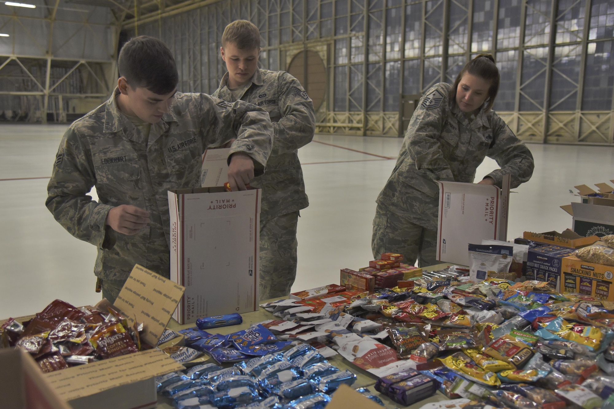 Team Fairchild volunteers pack Treats 2 Troops care packages with donated snacks Nov. 29, 2017, at Fairchild Air Force Base, Washington. KREM 2 News partnered with Team Fairchild for the seventh year in a row to fill care packages with small treats and gifts to help benefit military members serving overseas during the holiday season. (U.S. Air Force photo/Senior Airman Mackenzie Richardson)