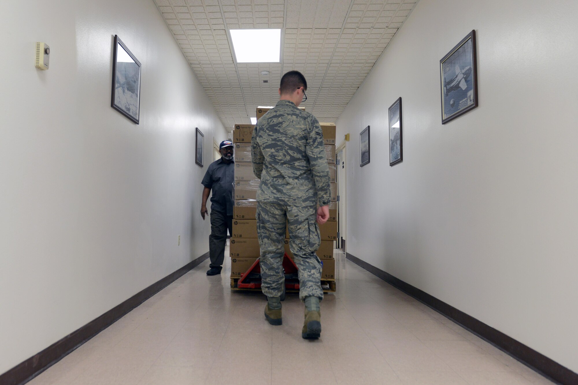 Airman 1st Class Aric McCartt, 673d Communication Squadron client systems technician, moves the next batch of computers to be imaged at Joint Base Elmendorf-Richardson, Alaska, Nov. 20, 2017. The 673d CS are able to image up to 48 computers in less than four hours on a single server after several innovative redesigns to their imaging process.