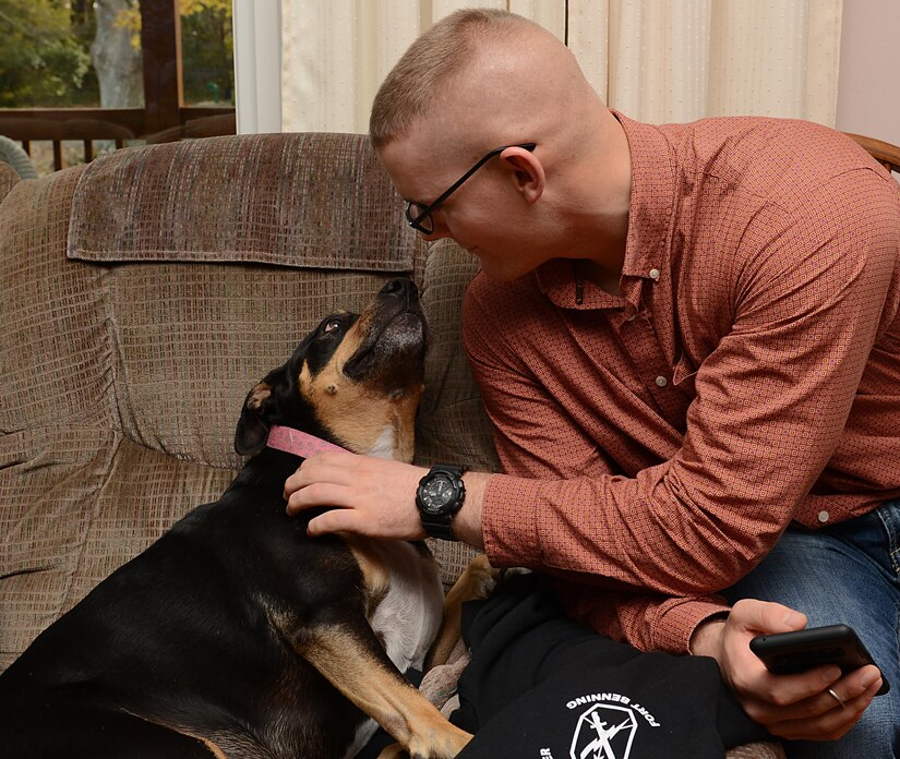 U.S. Army Private 1st Class Justin Hatfield, 128th Aviation Brigade Advanced Individual Training student, pets Roxy, the Deaver family pet, at their home in Yorktown, Va., Nov. 23, 2017.