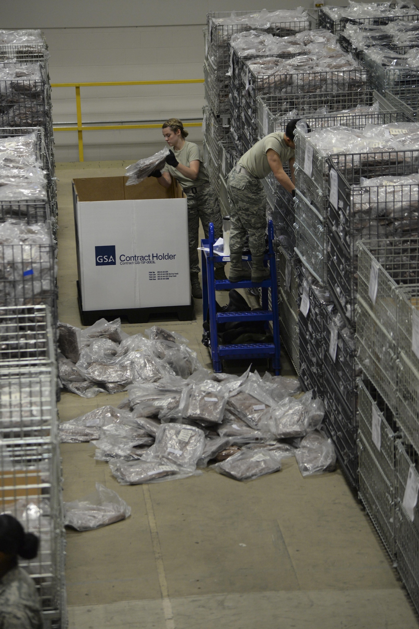 Airmen 1st Class Alizabeth Rawlings and Christian Rellorosa, 436th Logistics Readiness Squadron materiel management technicians, prepare individual protective equipment for a Civil Reserve Air Fleet readiness exercise Nov. 13, 2017, at Dover Air Force Base, Del. The IPE staff prepared nearly 1,250 full suits of chemical, biological, radiological and nuclear protective gear for shipment to two locations during the exercise. (U.S. Air Force photo by Staff Sgt. Aaron J. Jenne)