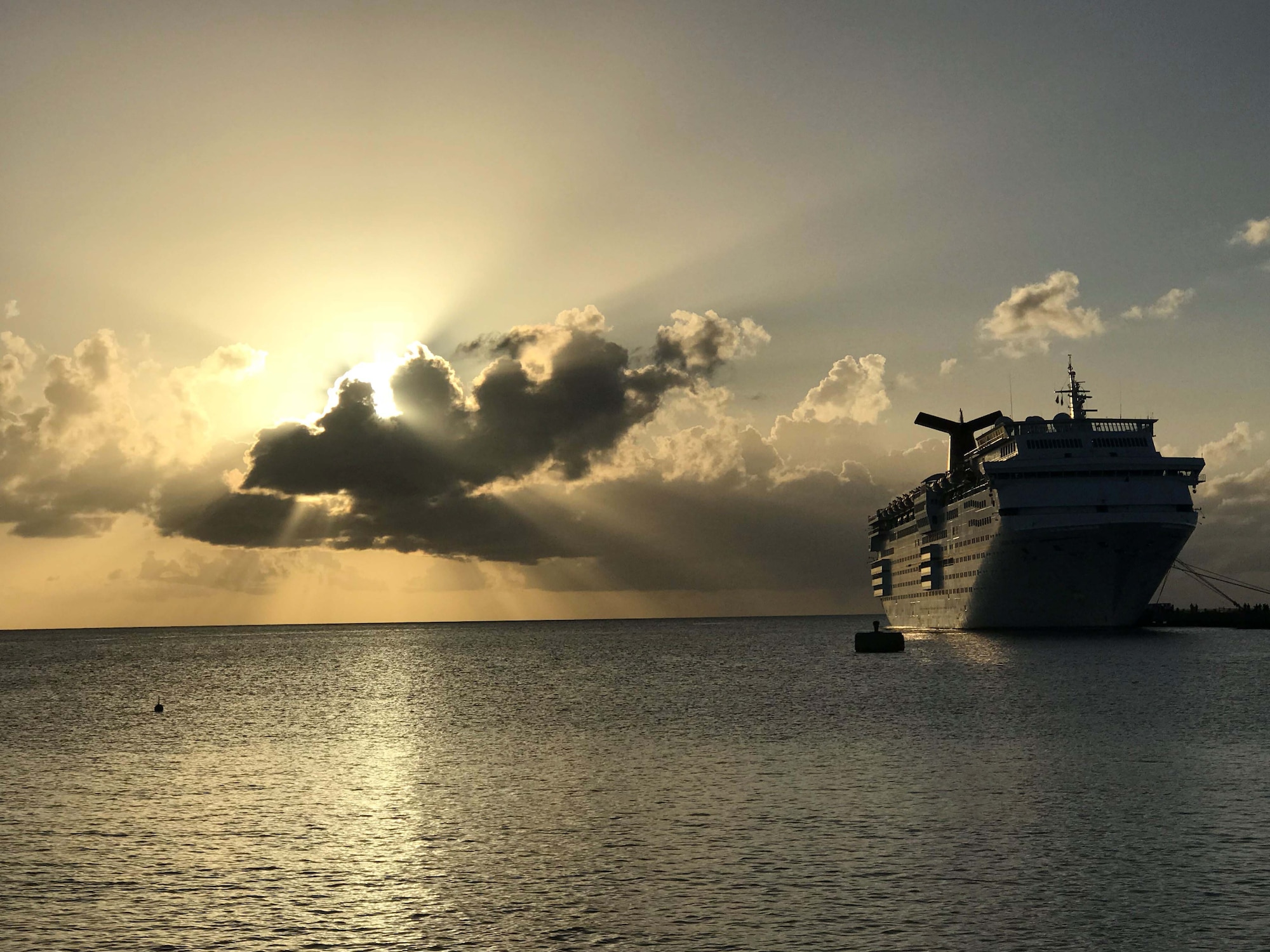 The sun slowly rises over the Lesser Antilles as Carnival Cruise Lines' ship, Fascination, can be seen moored at Frederiksted, St. Croix.  The docked ship was used to feed and house Federal Emergency Management Agency personnel who volunteered to help with disaster relief efforts after Hurricane Maria impacted the region in October 2017.  (U.S. Air Force photo by M. Claudette Wells)