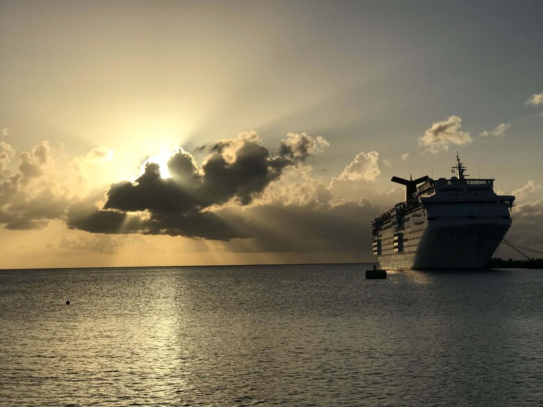 The sun slowly rises over the Lesser Antilles as Carnival Cruise Lines' ship, Fascination, can be seen moored at Frederiksted, St. Croix.  The docked ship was used to feed and house Federal Emergency Management Agency personnel who volunteered to help with disaster relief efforts after Hurricane Maria impacted the region in October 2017.  (U.S. Air Force photo by M. Claudette Wells)