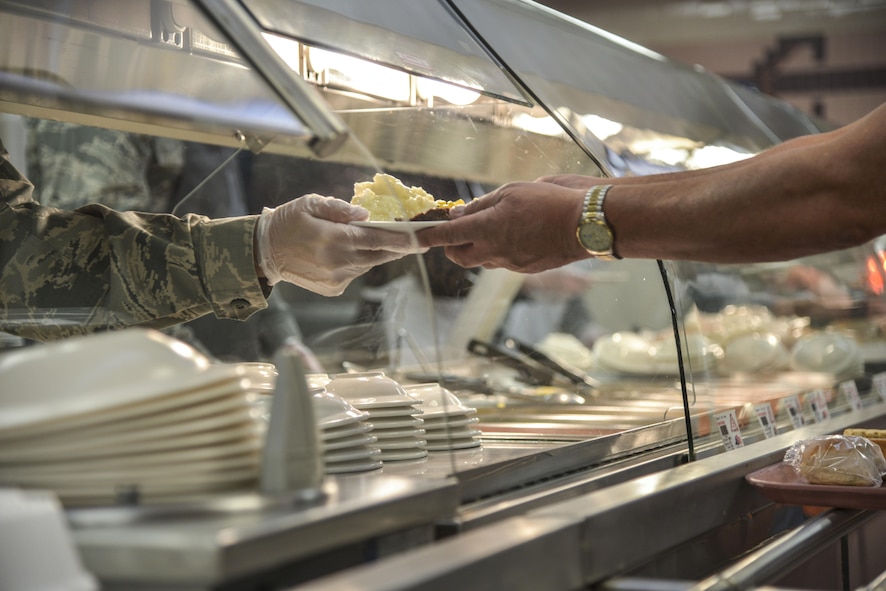 Chief Master Sgt. Chad Schulte, 377th Air Base Wing command chief, serves a holiday meal at the Thunderbird Inn Nov. 24. Several commanders and command chiefs took a shift serving meals at the dining facility on Thanksgiving to show their appreciation to all Airmen, retirees, and their families.