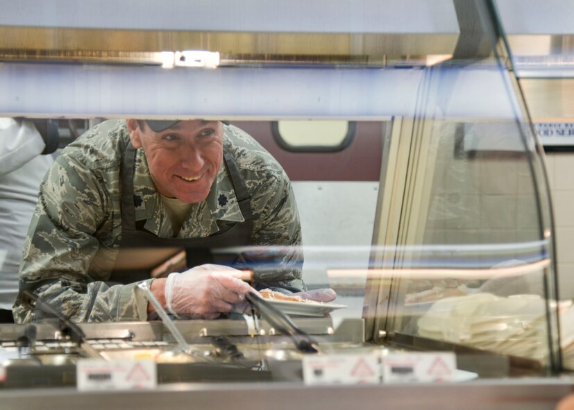 Lt. Col. Richard Reed, Force Support Squadron commander, serves holiday meals at the Thunderbird Inn Nov. 24. Several commanders and command chiefs took a shift serving meals at the dining facility on Thanksgiving to show their appreciation to all Airmen, retirees, and their families.