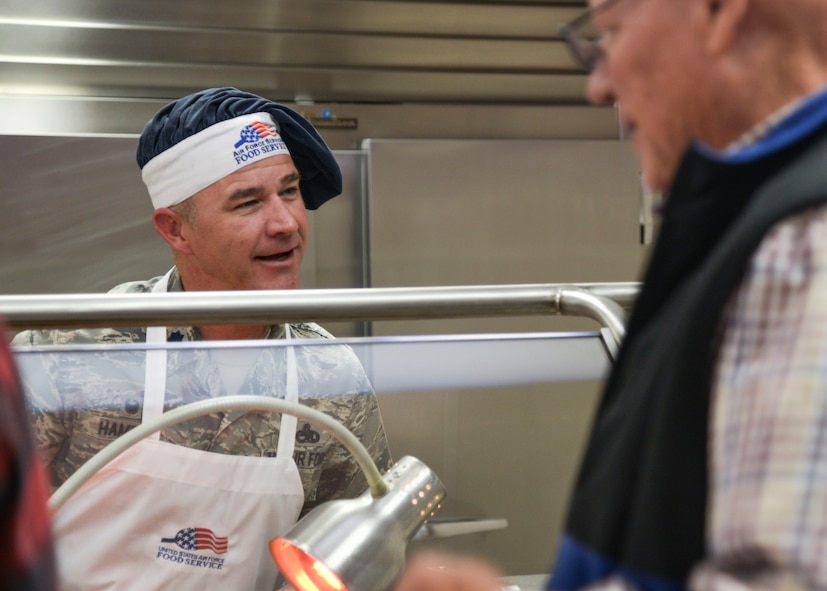 Lt. Col. John Hampel, 898th Munitions Squadron commander, serves holiday meals at the Thunderbird Inn Nov. 24. Several commanders and command chiefs took a shift serving meals at the dining facility on Thanksgiving to show their appreciation to all Airmen, retirees, and their families.