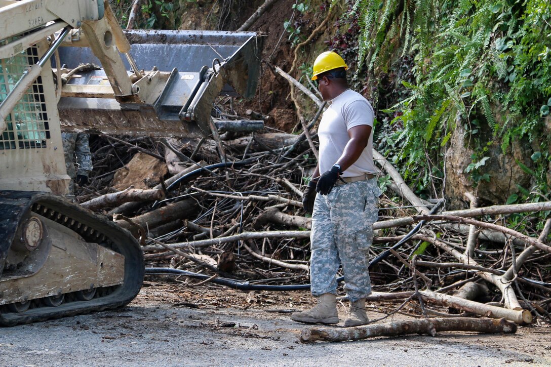 A National Guard soldier works in the clearance of a road.