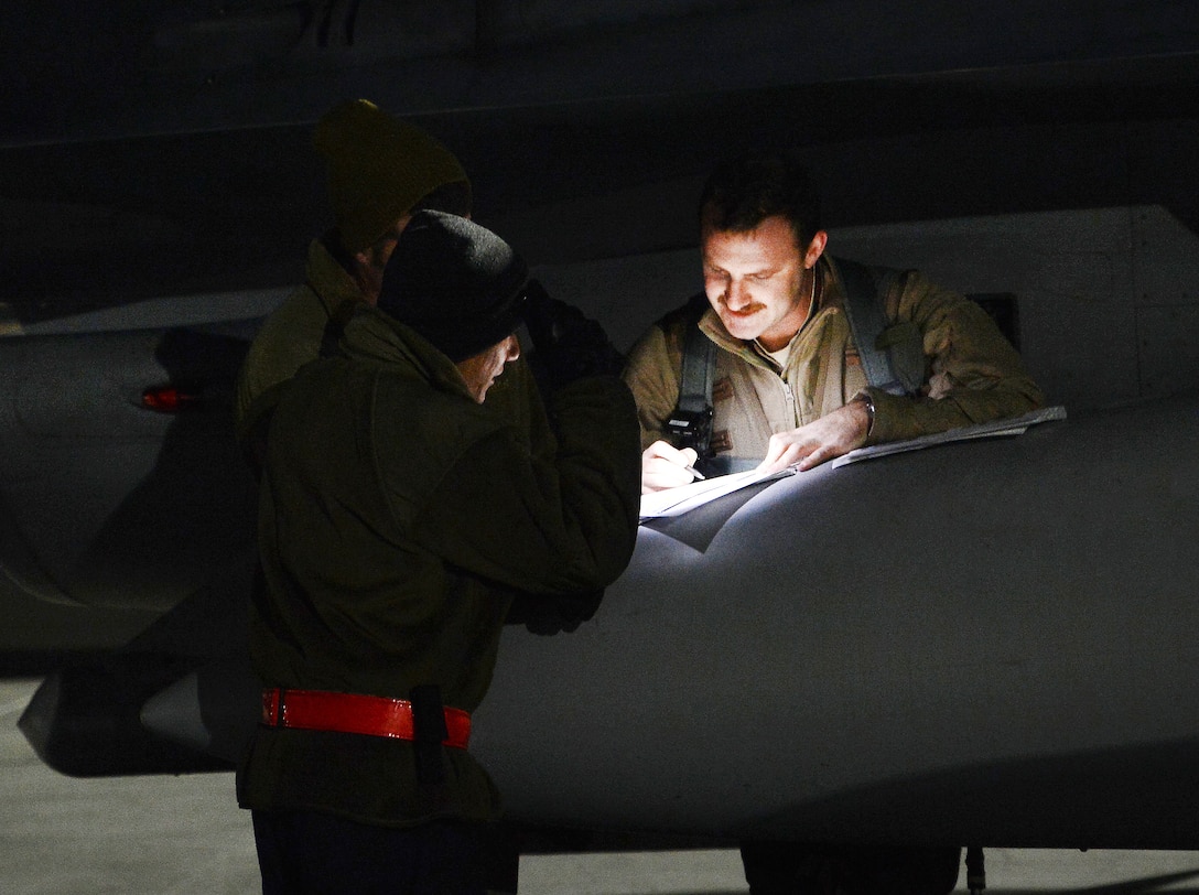An Air Force pilot and crew chief review flight plans before a mission from Bagram Airfield, Afghanistan.
