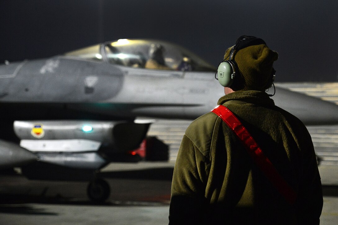 An Air Force crew chief observes an F-16 Fighting Falcon before a mission from Bagram Airfield, Afghanistan.