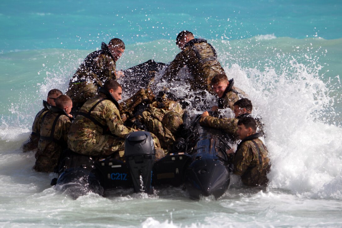 Soldiers climb into a combat rubber raiding craft on Marine Corps Training Area Bellows, Hawaii.