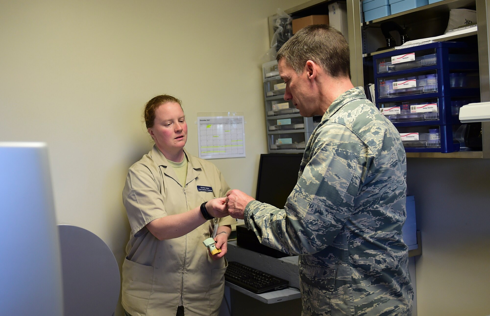 Tech. Sgt. Mary Sanders, 460th Medical Group dental laboratory technician, shows Maj. Gen. Robert. J. Skinner, Air Force Space Command deputy commander, the process it takes to make a crown for a patient Nov. 29, 2017, on Buckley Air Force Base, Colorado.