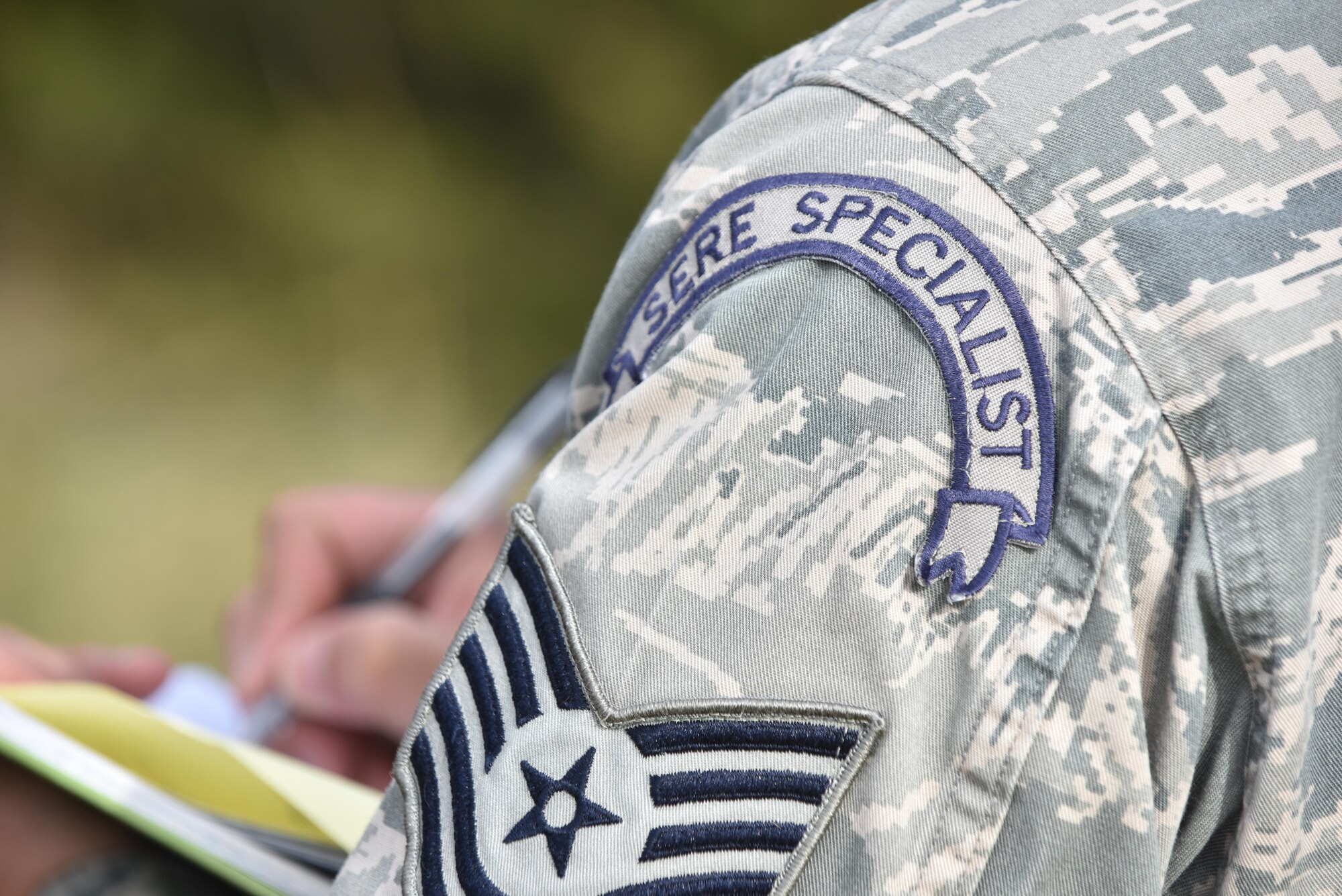 US Air Force Tech. Sgt. Sergio Avalos, a survival, evasion, resist and escape (SERE) specialist, trek through bushes with pilots of Team Whiteman to a designated starting area to conduct the navigation portion of their SERE training Nov.27, 2017 at Whiteman Air Force Base, Missouri. During this portion the pilots are must use given coordinates to locate a meeting point with the SERE instructor.