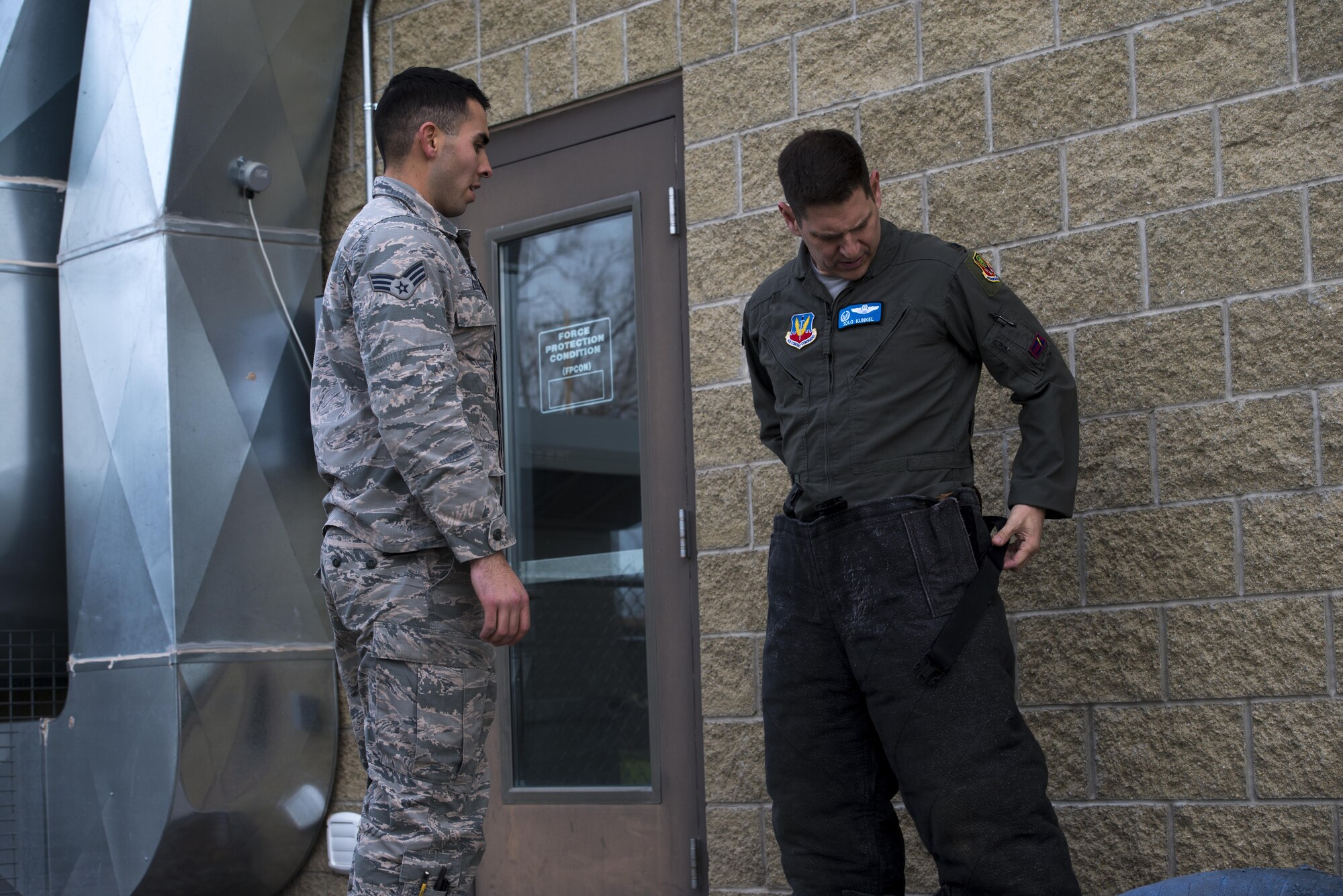 Senior Airman Kyle Maddox, 366th Security Forces Squadron military working dog trainer, instructs Col. Joeseph Kunkel, 366th Fighter Wing commander, on how to put on a bite suit Nov. 29, 2017, at Mountain Home Air Force Base, Idaho. The MWD obedience course is designed to place military working dogs in a basic setting to encounter obstacles they may face in real world situations.