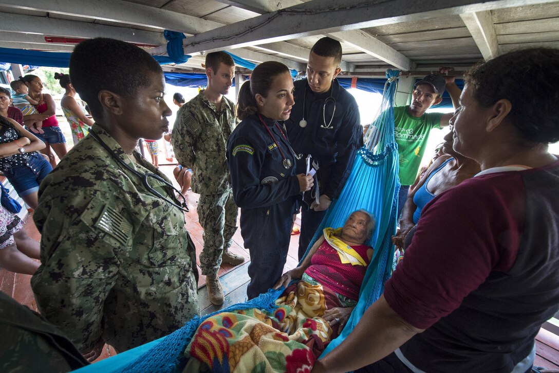 Navy specialists work to diagnose a woman on her houseboat.