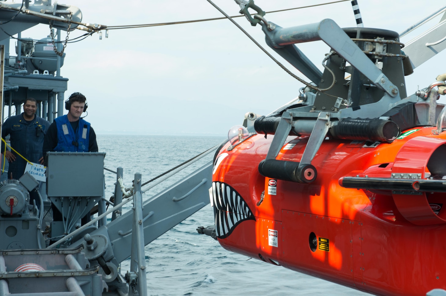 Mineman 1st Class Justin Crabtree, from Diamondhead, Miss., lowers a mine neutralization vehicle aboard the Avenger-class mine countermeasures ship USS Chief (MCM 14) into the water to track mines and simulate delivering an explosive package.