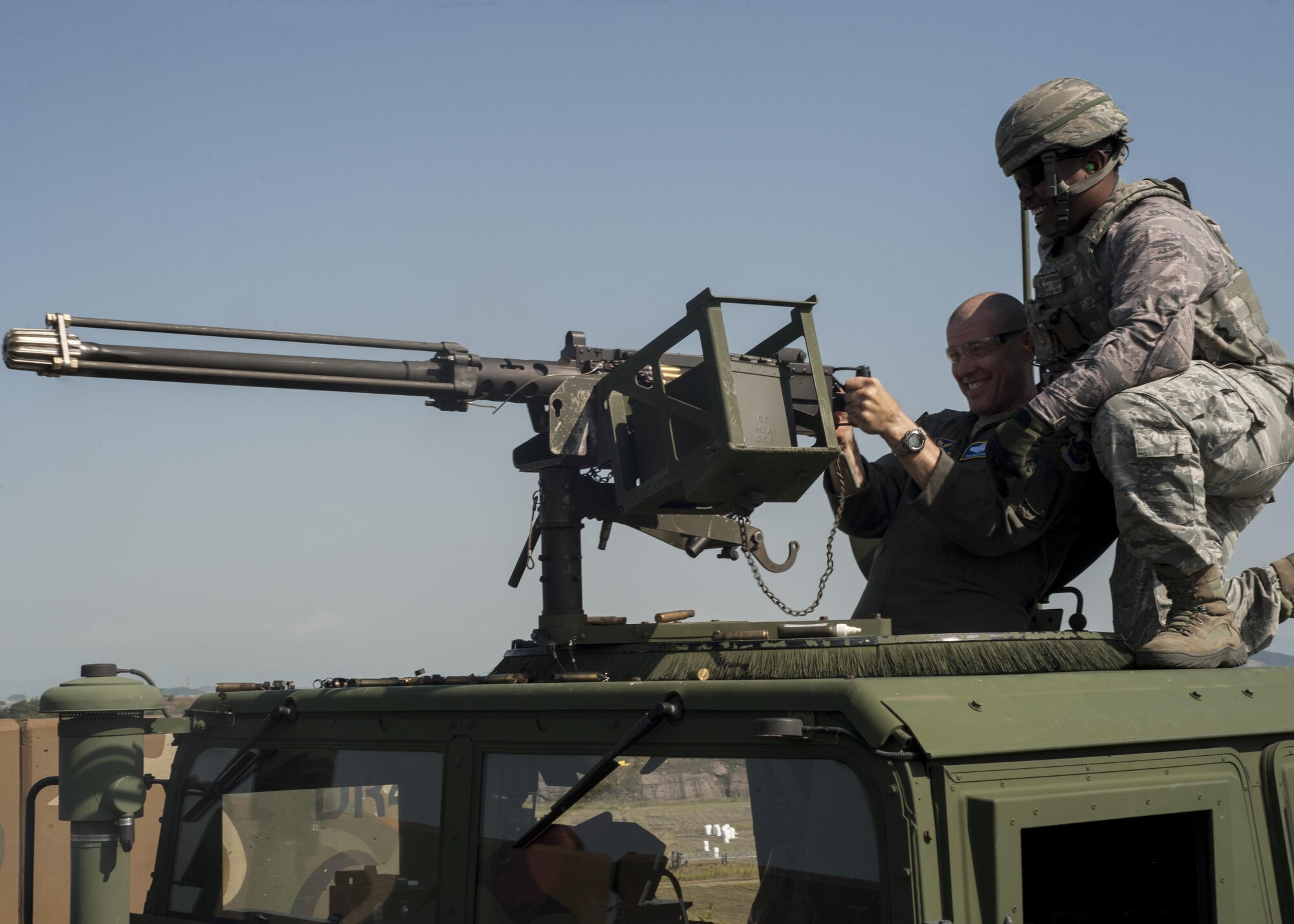 U.S. Air Force Maj. Gen. Thomas A. Bussiere, 8th Air Force commander, shoots a .50 caliber machine gun while Senior Airman Jaron Harris, 8th Security Forces Squadron defender, during a tour of Kunsan Air Base, Republic of Korea, Sept. 28, 2017.  During the tour, Bussiere and Gen. Robin Rand, Air Force Global Strike Command commander, experienced first-hand the capabilities of the Wolf Pack mission through demonstrations by squadrons such as the 8th Security Forces Squadron and its defenders. (U.S. Air Force photo by Staff Sgt. Victoria H. Taylor)
