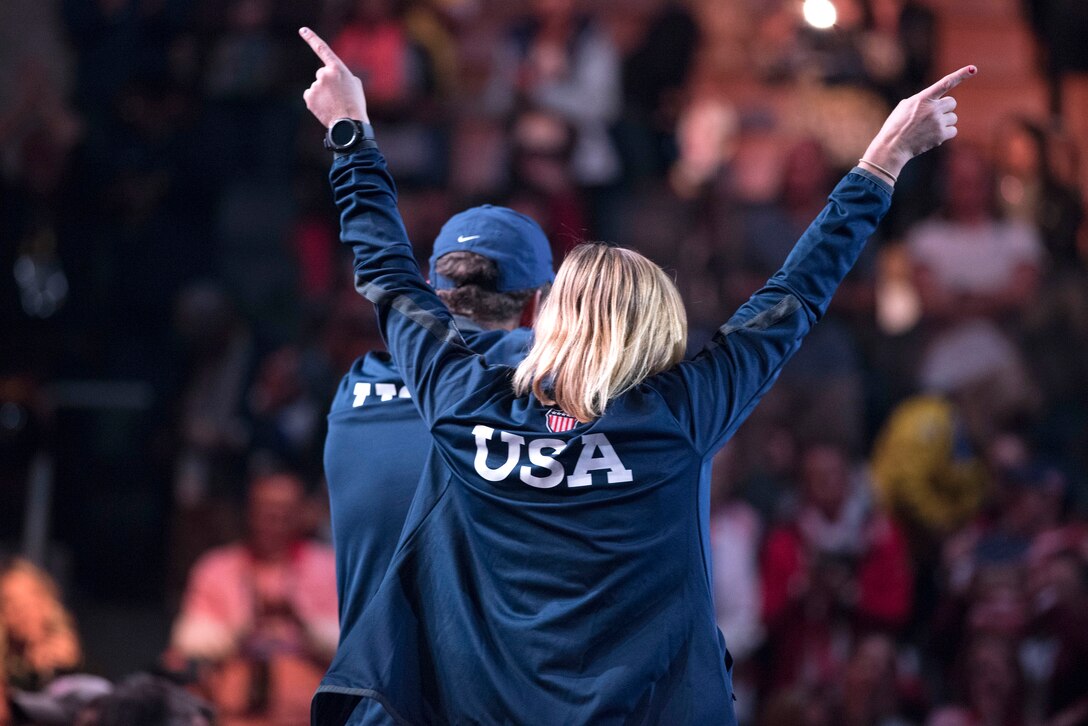 A member of Team U.S. raises her hands toward spectators.