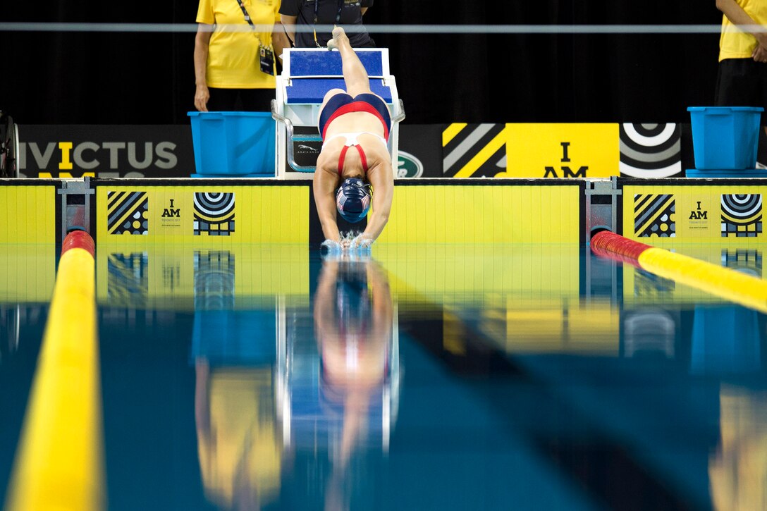 An airman dives into a pool of still water.