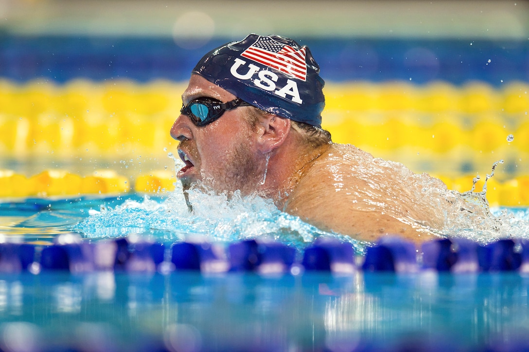 A retired sailor breathes as he competes in a breaststroke event.