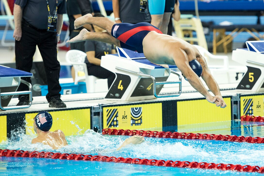 A swimmer dives into a pool to compete in an event.