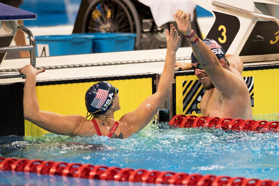 Two U.S. swimmers high-five each other after an event.