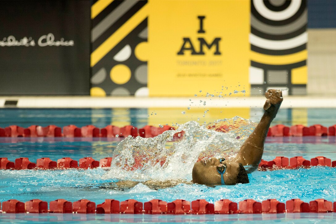 An Army veteran competes in a backstroke swimming finals.