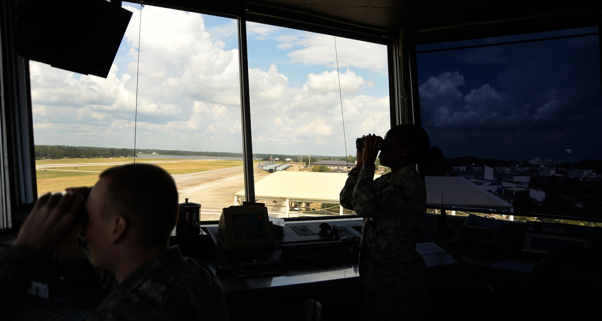 Senior Airman John Rode and Airman 1st Class Arafa Simmons, 81st Operations Support Flight air traffic controllers, look for incoming aircraft in the air traffic control tower Sept. 18, 2017, on Keesler Air Force Base, Mississippi. The air traffic controllers are responsible for approving the taxi, tow, departure and landing of aircraft as well as giving approval for personnel on the ground to access the airfield. The 81st OSF is responsible for all air operations. (U.S. Air Force photo by Airman 1st Class Suzanna Plotnikov)