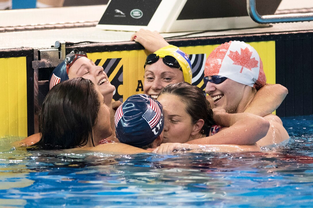 Athletes hug each other after a swimming event.