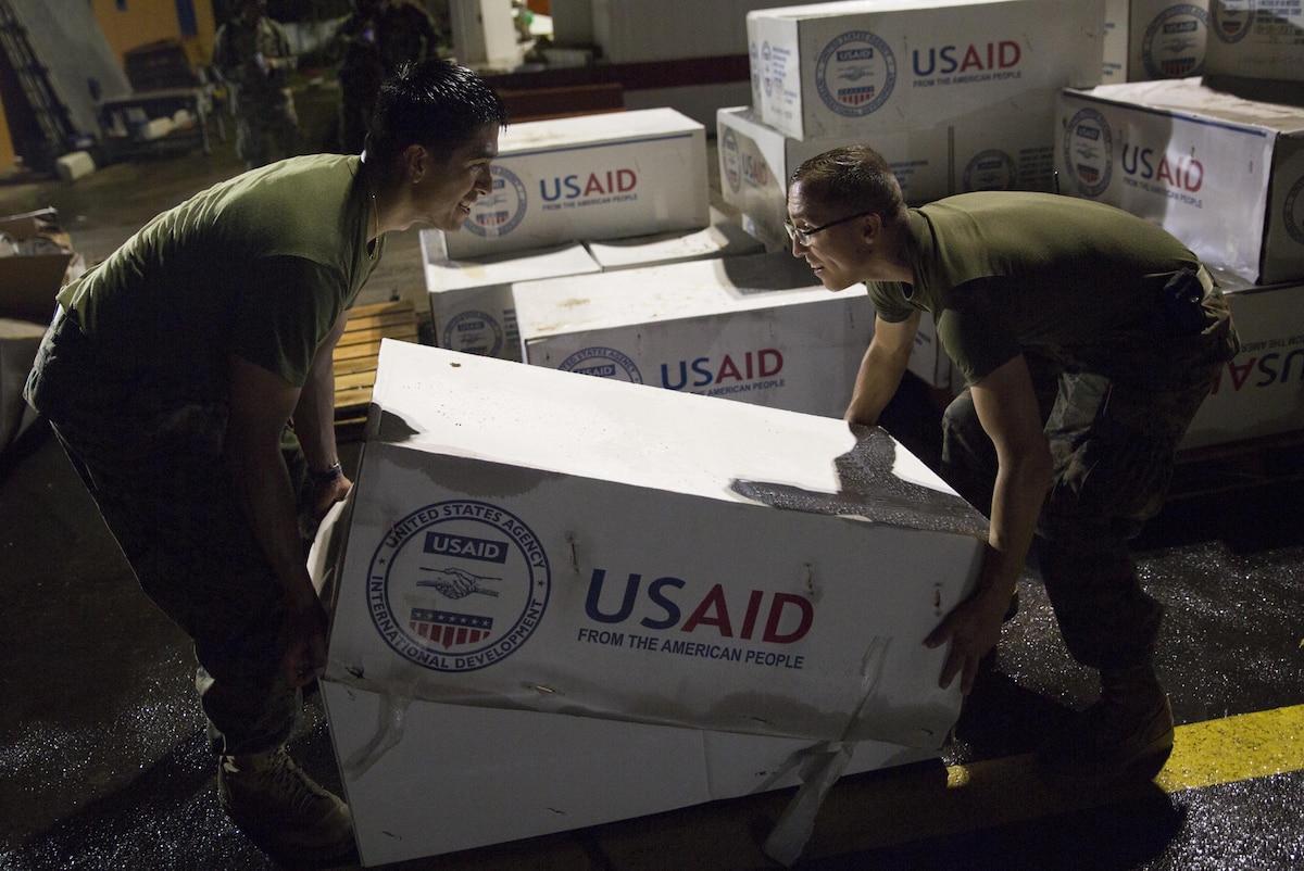 U.S. Marines stack boxes of tarps as they prepare supplies for distribution in Dominica.