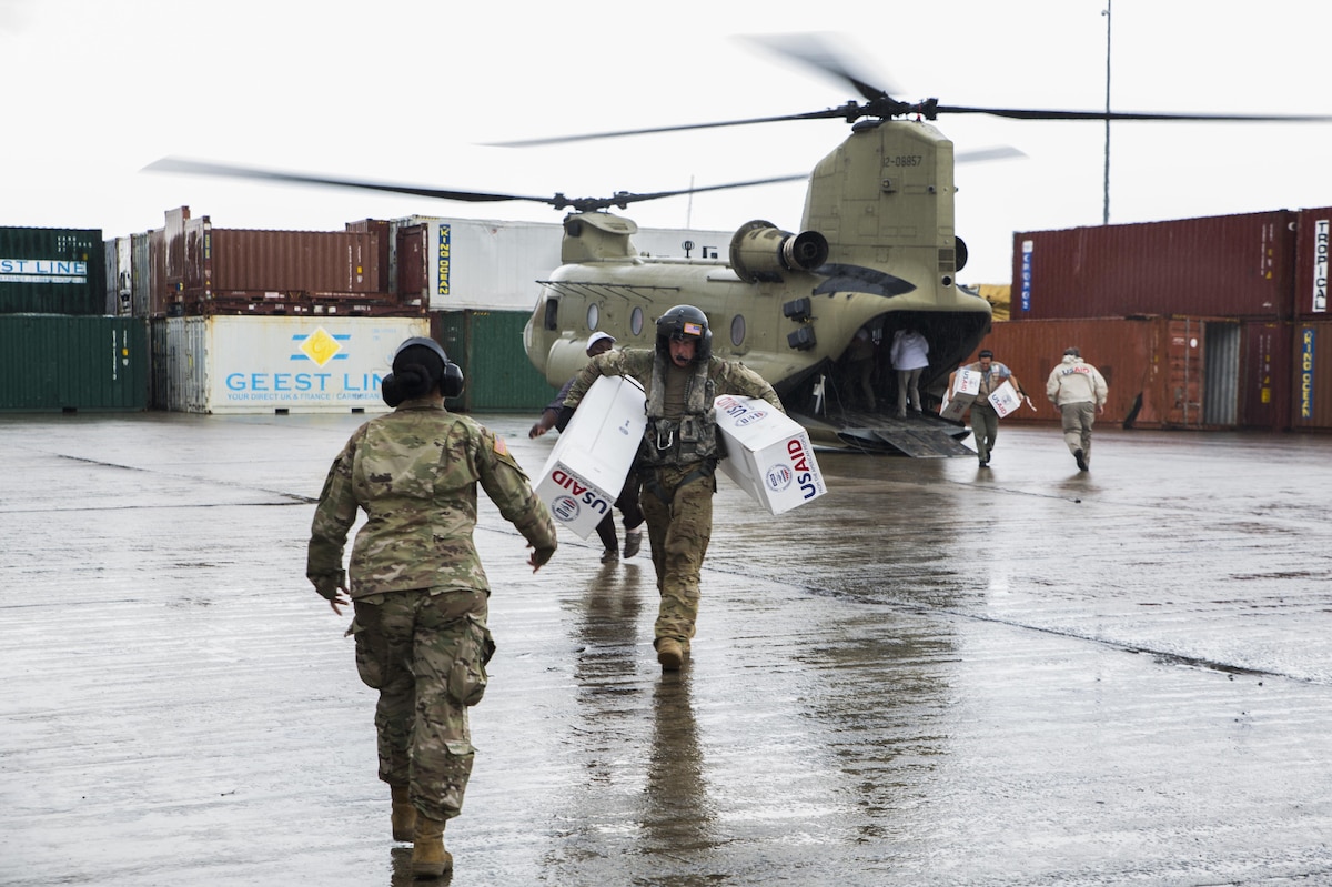 U.S. service members unload supplies from a U.S. Army helicopter in Dominica.
