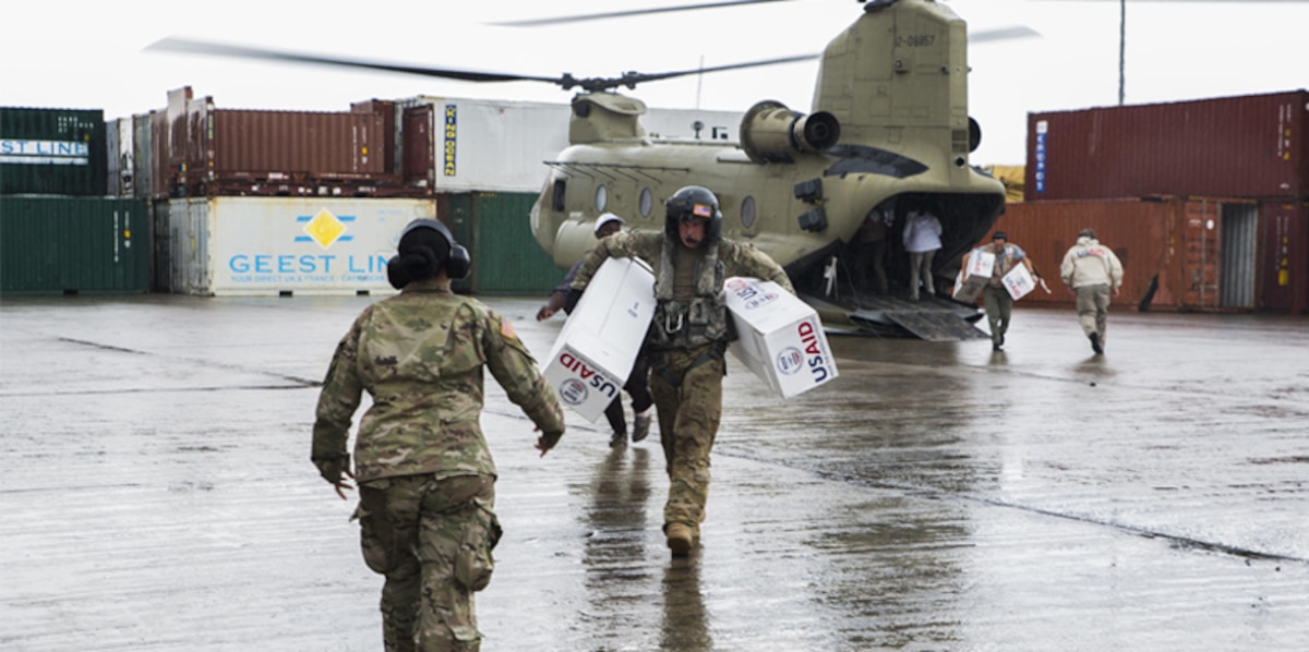 U.S. service members unload supplies from a helicopter in Dominica.