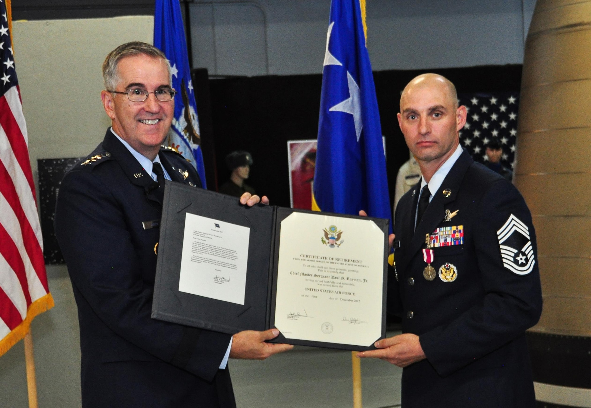 Chief Master Sgt. Paul Rayman and Gen. John E. Hyten, Commander, United States Strategic Command, pose for a photo during Rayman's retirement ceremony at the Peterson Air Force Base Air and Space Museum on Saturday, Sep. 9, 2017.