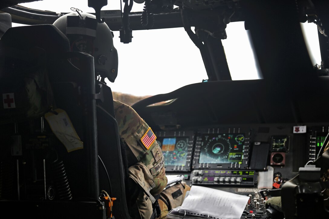 A soldier flies an HH-60 Black Hawk helicopter.