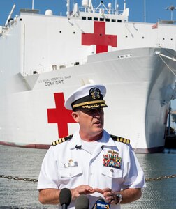 A Navy commander answers questions during a news conference.